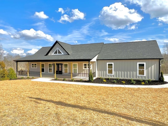 view of front facade with a porch, board and batten siding, and roof with shingles