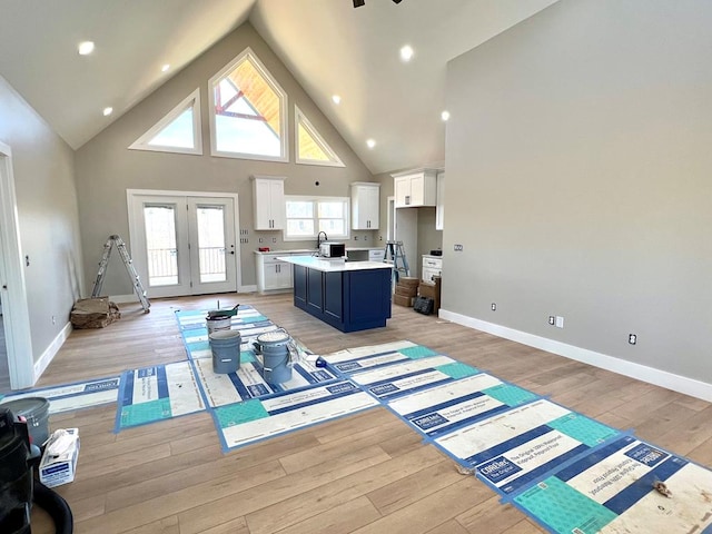 interior space featuring high vaulted ceiling, light wood-type flooring, french doors, and baseboards