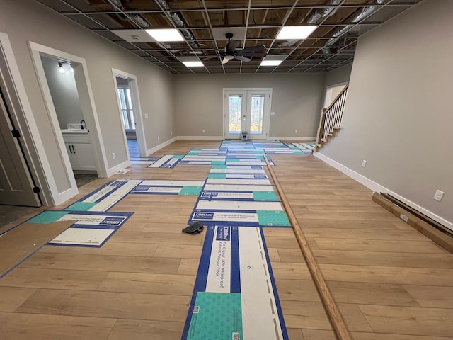 workout room featuring a sink, baseboards, wood finished floors, and french doors