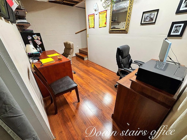 home office with wood finished floors and concrete block wall