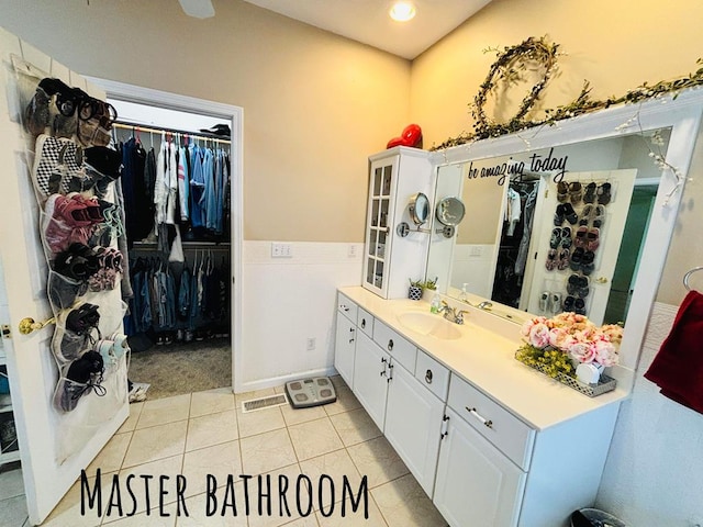 bathroom featuring visible vents, a walk in closet, vanity, and tile patterned floors