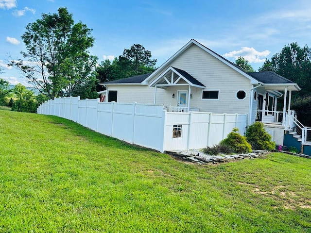 view of side of home featuring a yard and fence