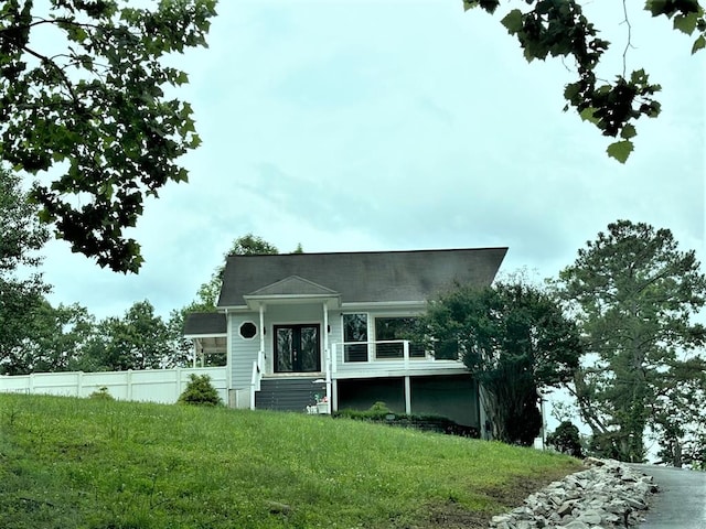 view of front of property featuring fence and a front lawn