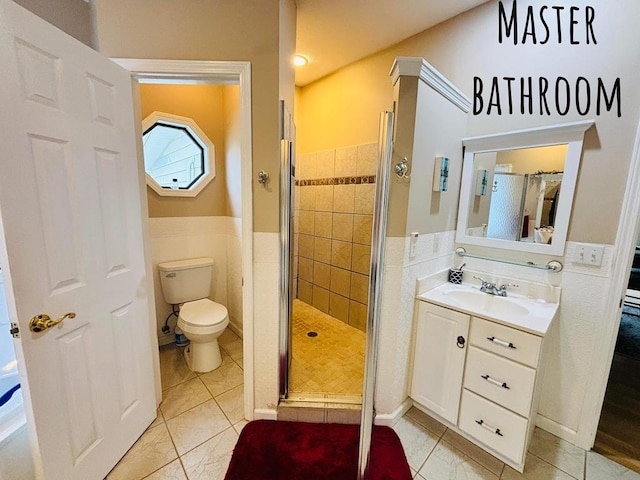 bathroom featuring toilet, a stall shower, wainscoting, and vanity