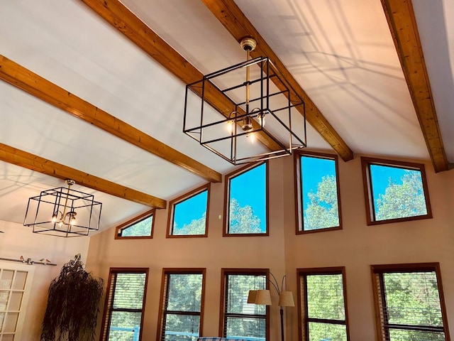 interior space with lofted ceiling with beams and an inviting chandelier