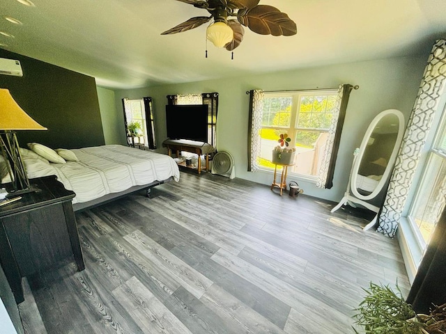 bedroom with ceiling fan, multiple windows, and wood finished floors