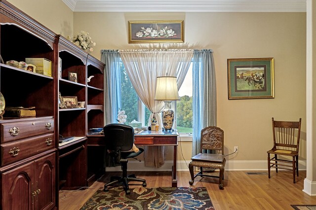 home office with ornamental molding, light wood-style flooring, and baseboards