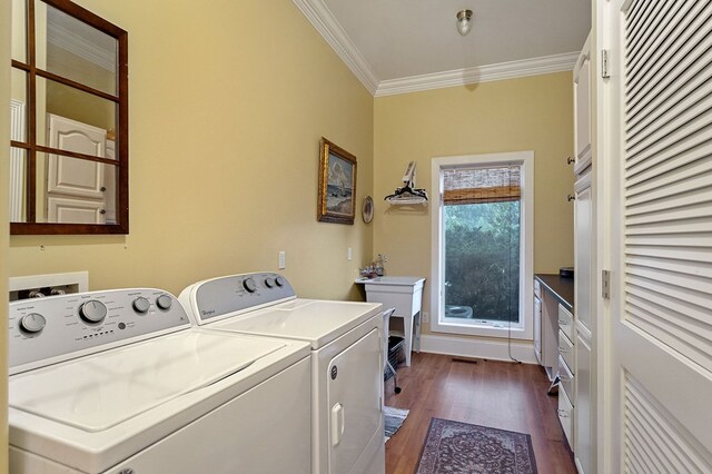 washroom featuring washing machine and dryer, laundry area, dark wood-type flooring, visible vents, and crown molding