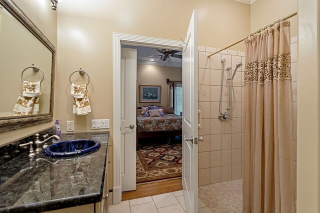 ensuite bathroom with a ceiling fan, connected bathroom, tile patterned floors, vanity, and a shower stall