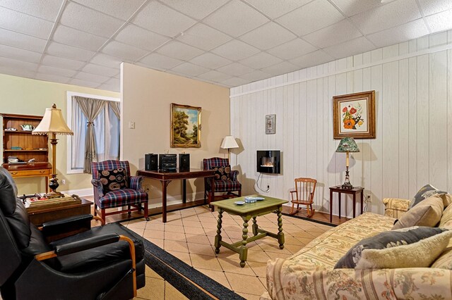 living area with light tile patterned floors and a drop ceiling