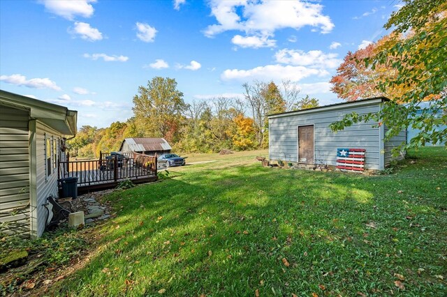 view of yard with a deck and an outbuilding