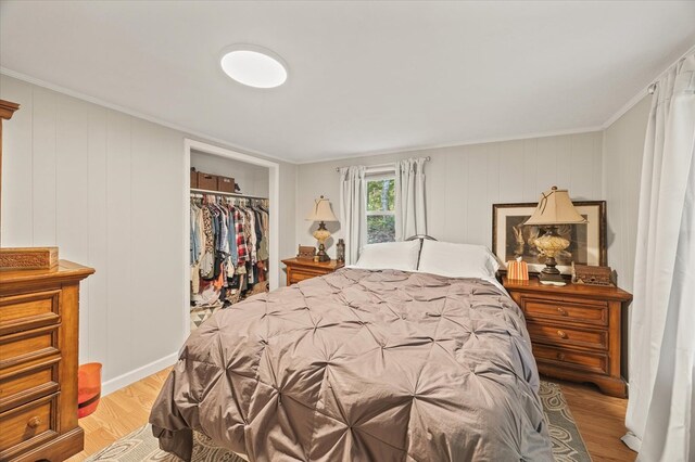 bedroom with ornamental molding, a closet, and light wood-type flooring