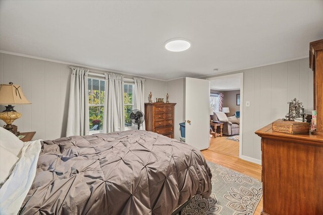 bedroom with ornamental molding and light wood-style flooring