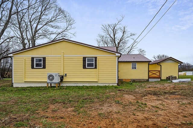 back of house featuring ac unit and metal roof