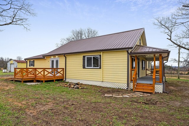 rear view of property with covered porch and metal roof