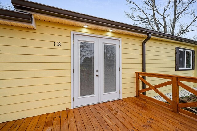 view of exterior entry with a wooden deck and french doors