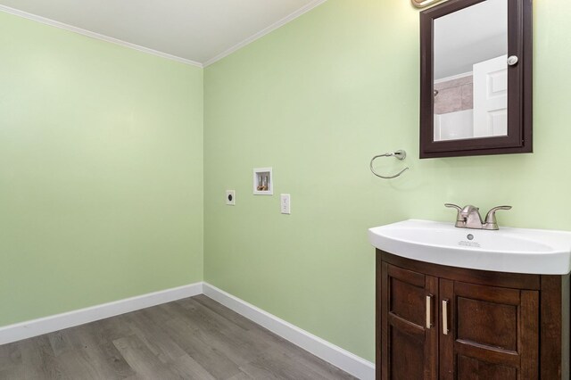 bathroom with crown molding, baseboards, wood finished floors, and vanity