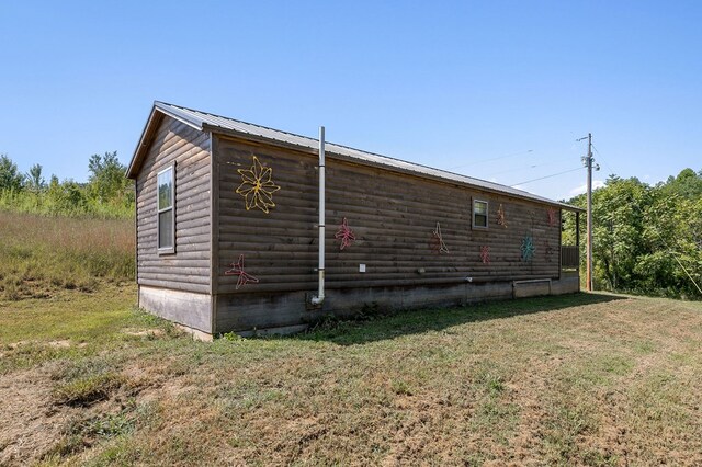 view of home's exterior with log veneer siding, a yard, and metal roof