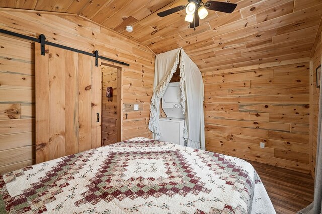 unfurnished bedroom featuring a barn door, wood ceiling, wood walls, and vaulted ceiling