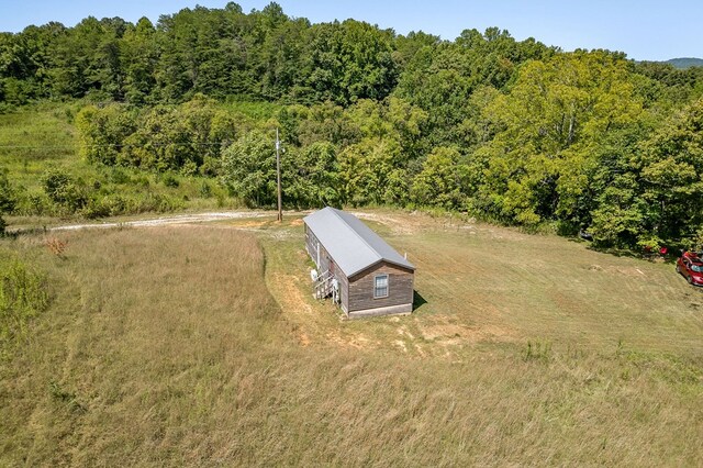 birds eye view of property featuring a rural view and a wooded view