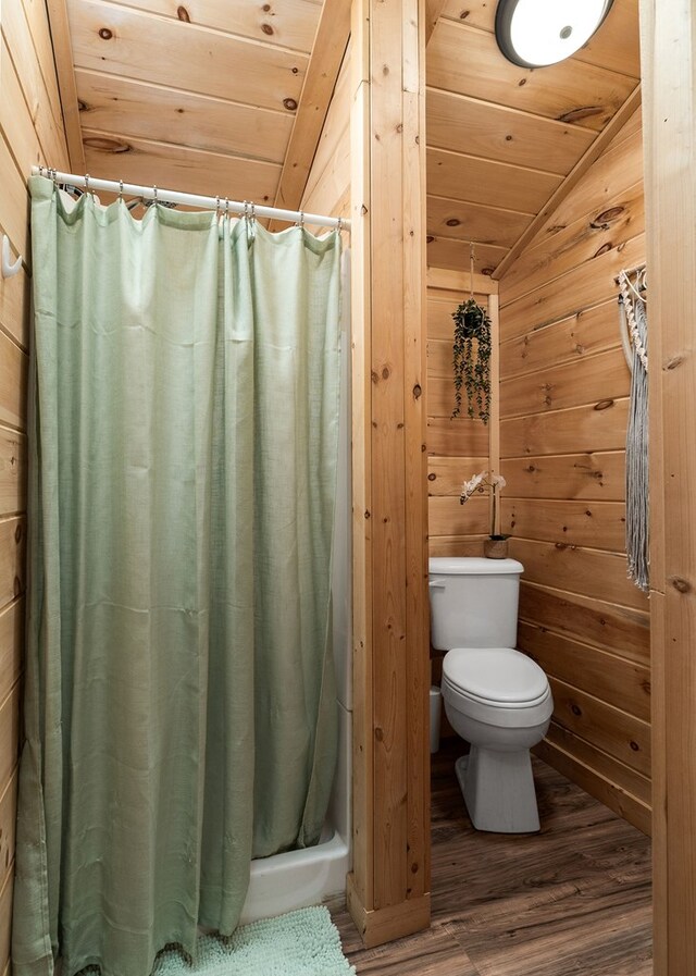 bathroom with wooden ceiling, toilet, wood finished floors, and wood walls