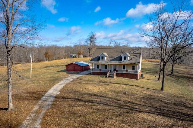 view of front of property featuring driveway, a front lawn, a porch, and an outdoor structure