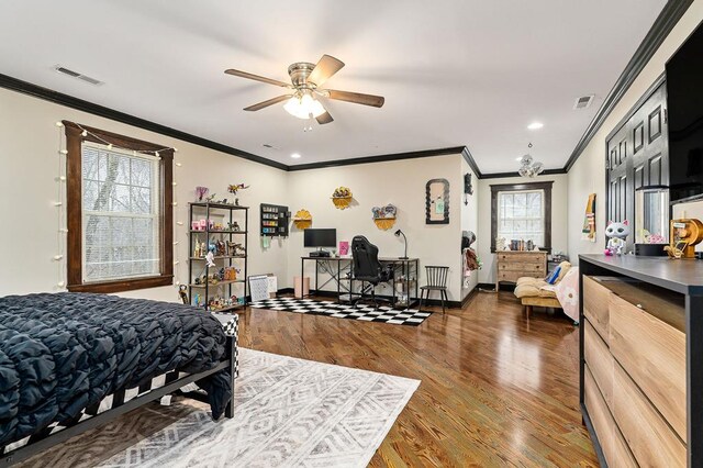 bedroom featuring visible vents, multiple windows, and wood finished floors