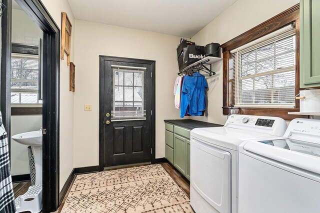 laundry area with baseboards, washing machine and clothes dryer, cabinet space, and a healthy amount of sunlight