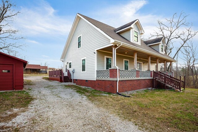 view of front of home featuring covered porch, driveway, crawl space, and a front yard