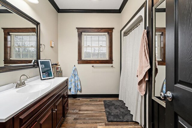 full bath with a wealth of natural light, vanity, crown molding, and wood finished floors