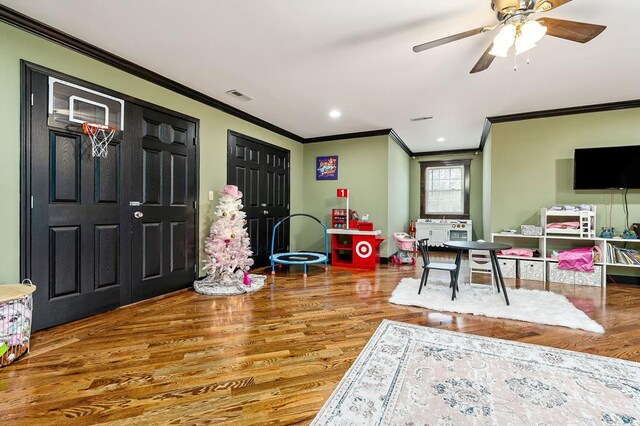 rec room featuring crown molding, recessed lighting, visible vents, a ceiling fan, and wood finished floors