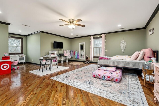 bedroom featuring baseboards, wood finished floors, visible vents, and crown molding