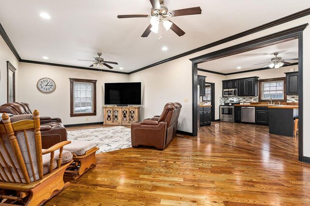 living room featuring recessed lighting, wood finished floors, a ceiling fan, and baseboards