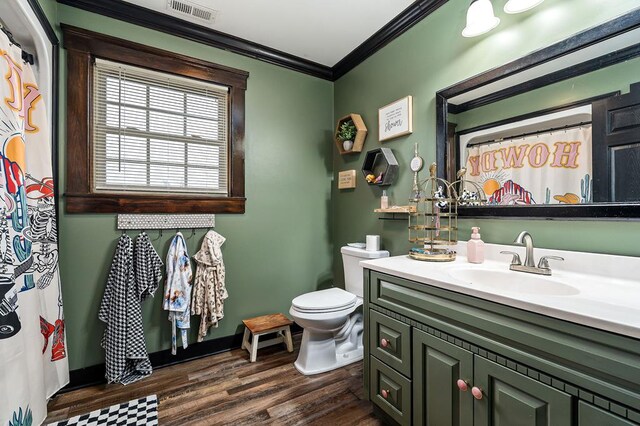 bathroom featuring visible vents, toilet, wood finished floors, crown molding, and vanity