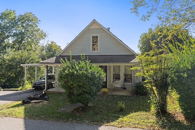 view of property exterior featuring aphalt driveway, an attached carport, and a porch