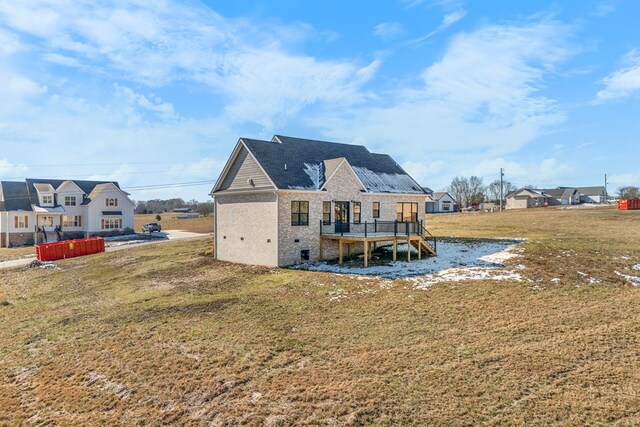 rear view of property featuring a deck, a yard, and a residential view