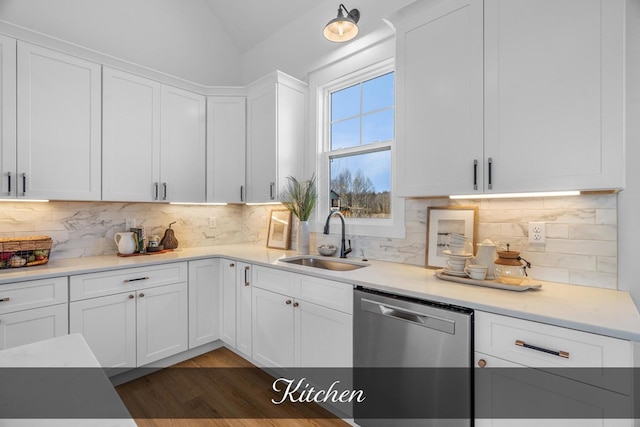 kitchen with white cabinets, light countertops, a sink, and stainless steel dishwasher