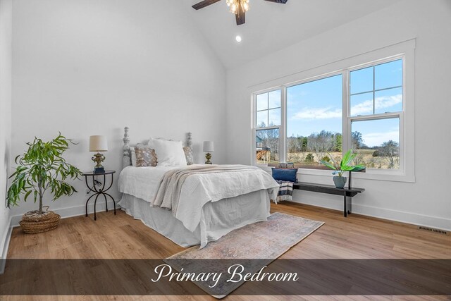 bedroom with high vaulted ceiling, a ceiling fan, light wood-style flooring, and baseboards