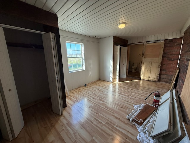 unfurnished bedroom with wooden ceiling and light wood-style flooring