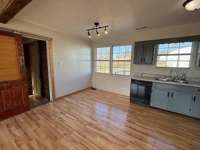 kitchen with light wood finished floors, light countertops, a sink, a textured ceiling, and dishwasher