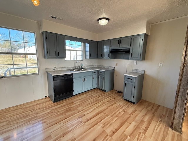 kitchen with black dishwasher, visible vents, light countertops, and light wood-style flooring