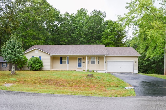 ranch-style home featuring a garage, a front lawn, and aphalt driveway