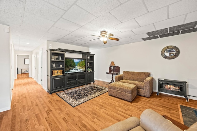 living room with baseboards, a ceiling fan, wood finished floors, and a glass covered fireplace