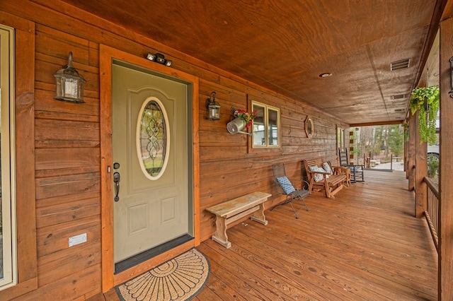 view of exterior entry with a porch, crawl space, and visible vents