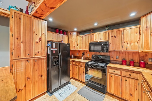 kitchen with black appliances, light wood-type flooring, and recessed lighting