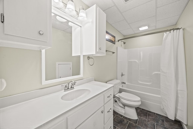 full bathroom with a paneled ceiling, shower / tub combo, toilet, and vanity