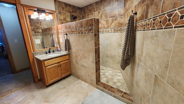 full bathroom featuring tile patterned floors, vanity, and a walk in shower