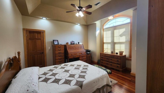 bedroom featuring a ceiling fan, visible vents, dark wood finished floors, and baseboards