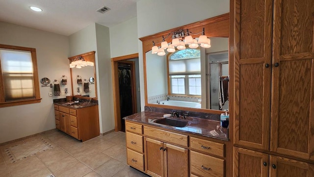 bathroom with two vanities, a sink, visible vents, a shower stall, and tile patterned floors