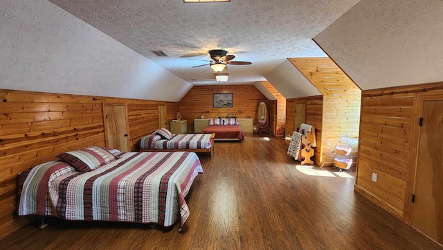 bedroom with dark wood-style flooring, visible vents, vaulted ceiling, wooden walls, and a textured ceiling